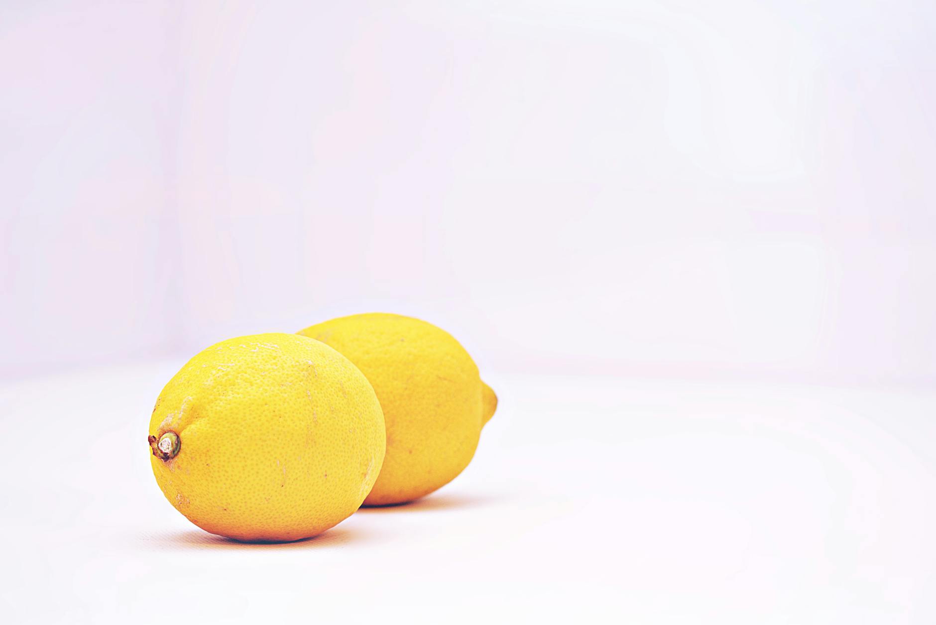 Two vibrant lemons on a white background, symbolizing fresh approaches to pleasure and self-acceptance