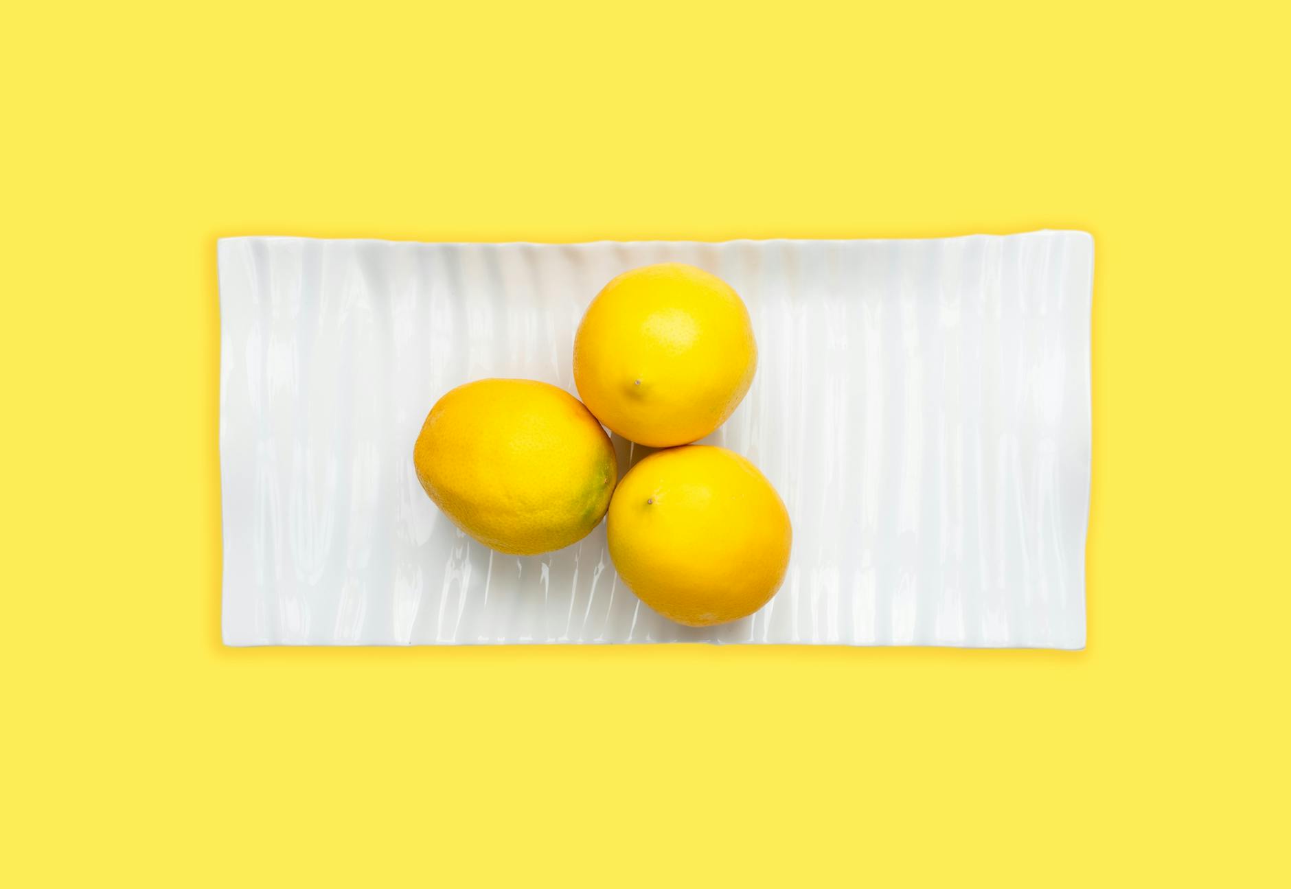 Fresh lemons arranged on a white surface, symbolizing intensity and vitality.